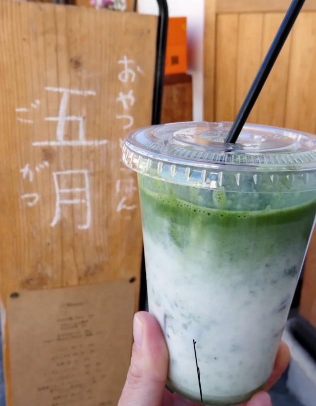 五月のお店の看板の前で
