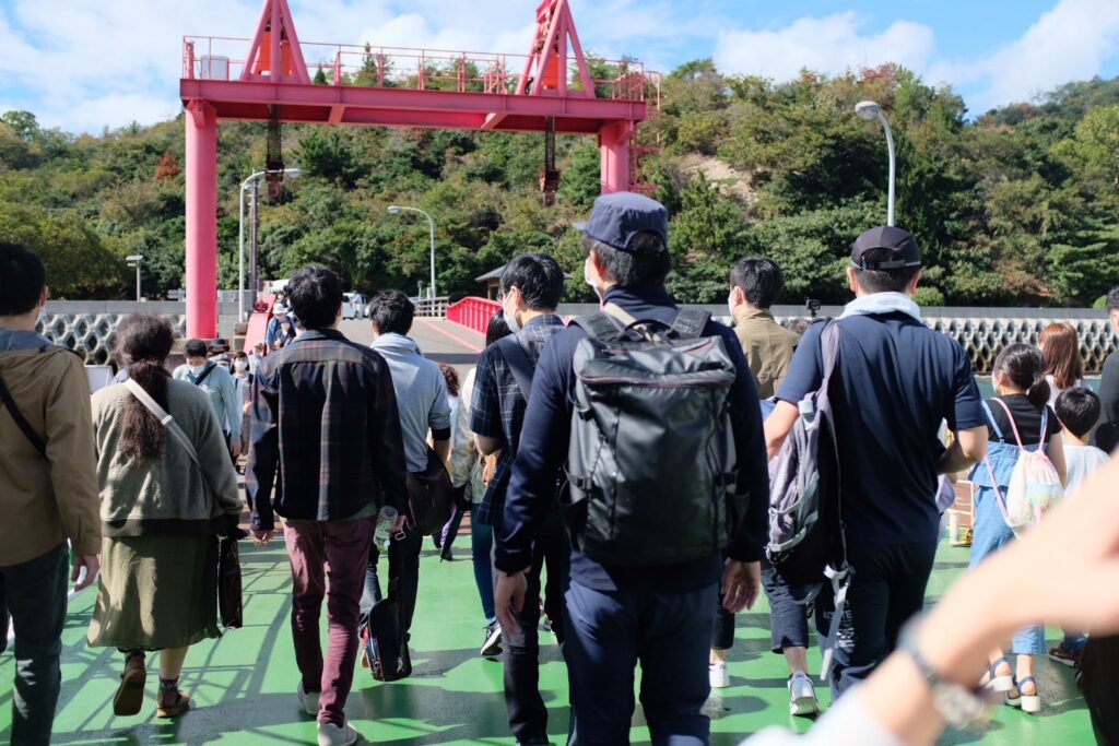 フェリーから降りて、一斉に大久野島に向かうたくさんの人たちの画像