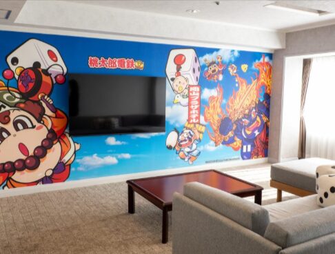 岡山プラザホテル、桃鉄ルームのリビングの風景。壁には、キングボンビーたちが映っています。